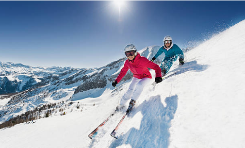 deux personnes qui descendent une montagne en ski